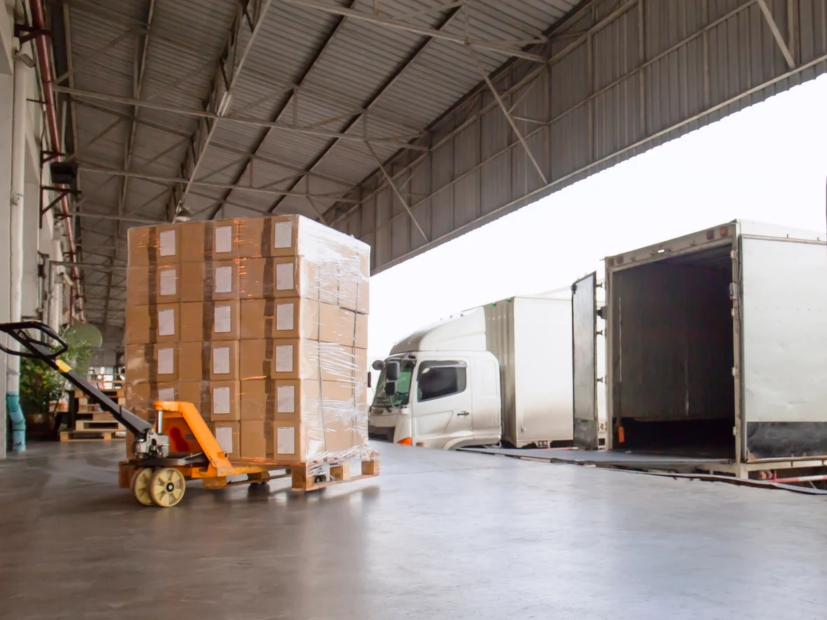 Palletized cargo being loaded onto a truck at a warehouse dock